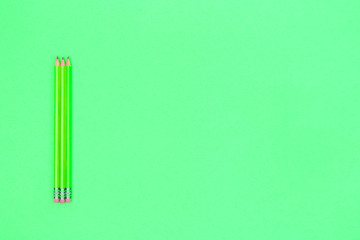 Pencils on a neon green background. Back to school concept. Horizontal