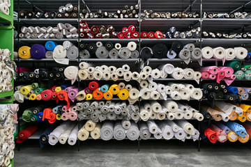 Fabric warehouse with many multicolored textile rolls - 277341688