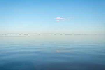 Rio de la plata en calma con fina linea de costa en el horizonte, entre Argentina e Uruguay