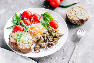 Breakfast fried egg with mushrooms champignons and arugula