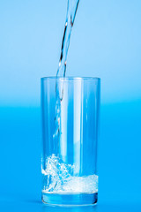 Close up pouring purified fresh drink water from the bottle on table