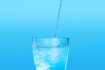 Close up pouring purified fresh drink water from the bottle on table