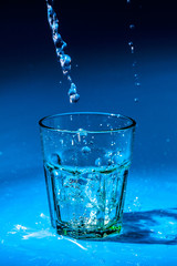 Close up pouring purified fresh drink water from the bottle on table
