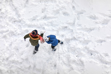 Aerial above view of two little children playing in the snow