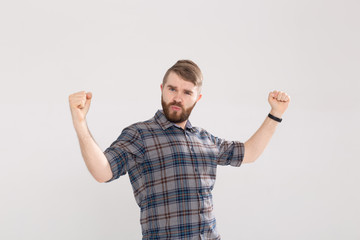 Emotion, success, gesture and people concept - young man in glasses celebrating victory over pink background