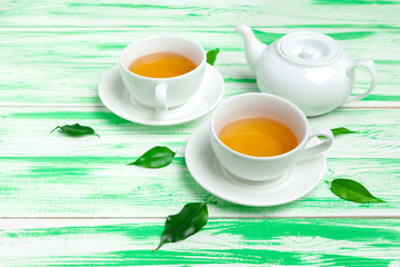 Black tea on green wooden background
