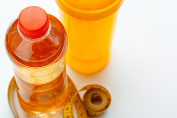 Bottled water for healthy life and measuring tape over a white background