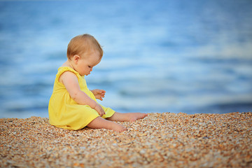Fototapeta na wymiar ittle girl in a yellow dress near the sea