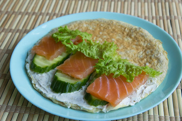 Sandwich of oatmeal, red fish salmon, cucumber, cheese, lettuce