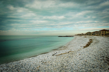 Fototapeta na wymiar La spiaggia di sassi a Marina di Pisa in una giornata invernale