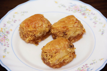 traditional Turkish puff sweetness baklava with nuts on white plate