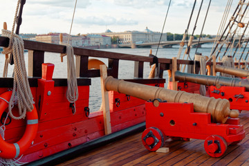 Historical cannon of an old wooden sailboat. Details deck of the ship.
