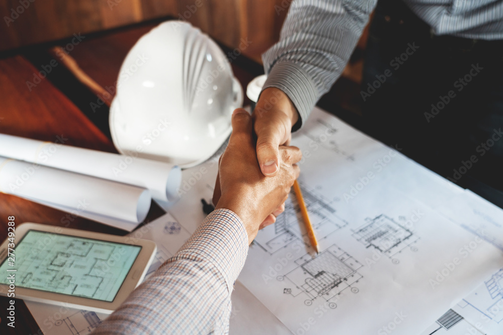 Aufkleber architect and engineer construction workers shaking hands while working for teamwork and cooperation