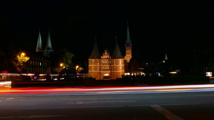 Fototapeta na wymiar The famous Holsten Gate with night traffic blur in Lubeck, Germany