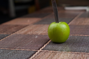 Beautiful green apple with knife on the kitchen table.Green fruit
