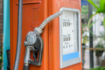close up nozzle fuel with Vintage gas pump machine for fill oil in Thailand.