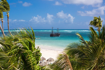 the Pirate ship in the turquoise sea view through the palm trees. Pirates of the Caribbean. Los...