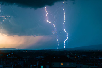 Storm and lightning over city during day