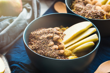 Turmeric amaranth porridge served with apples, flax seeds and almonds. Healthy plant based vegan breakfast.