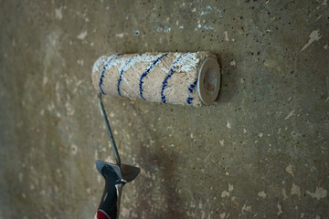 large roller to paint on the background texture of gray concrete wall
