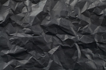 Background of crumpled sheet of black paper.