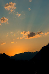 golden orange sunset with mountain silhouette and fading blue sky
