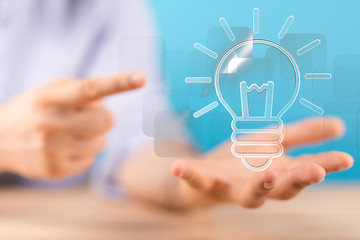  holding illuminated light bulb, idea, innovation and inspiration concept.