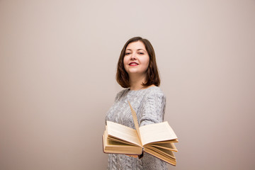 Portrait of young brunette woman with book in her hand