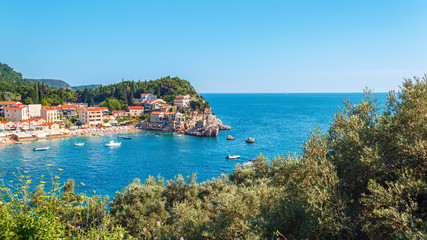 Fototapeta na wymiar Picturesque summer view of Adriatic sea coast in Budva Riviera. Przno village with buildings on the rock, Montenegro