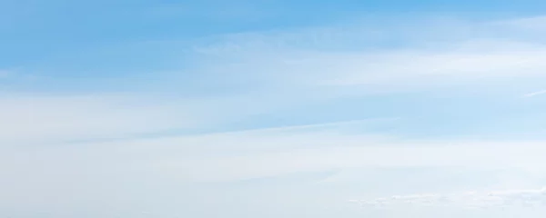 Wandaufkleber Blauer Himmel mit windigen Zirruswolken tagsüber © evannovostro