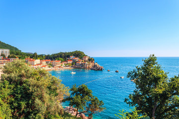 Naklejka premium Picturesque summer view of Adriatic sea coast in Budva Riviera. Przno village with buildings on the rock, Montenegro