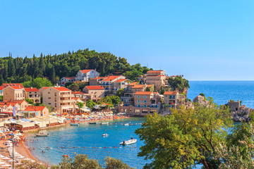 Picturesque summer view of Adriatic sea coast in Budva Riviera. Przno village with buildings on the...