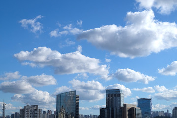 Fototapeta na wymiar Flat cityscape with blue sky, white clouds and sun. Modern city skyline flat panoramic background. Urban city tower skyline illustration