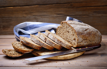Freshly baked sliced bread on rustic wooden background