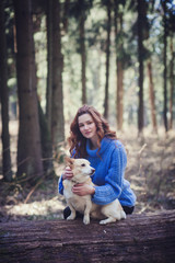 Naklejka na ściany i meble cute girl in a sweater sitting with a dog in the woods