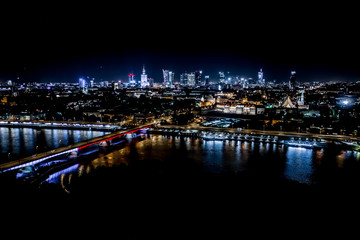 Obraz na płótnie Canvas Night city skyline background. Aerial view of Warsaw capital city of Poland. From above, night city view with night sky. Night panorama of Warsaw cityscape. Aerial View