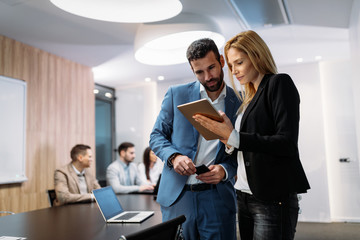 Businesspeople discussing while using digital tablet in office