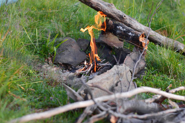 Cooking in a pot over campfire.Sunlight.Mountains.