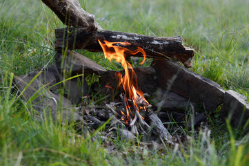 Cooking in a pot over campfire.Sunlight.Mountains.