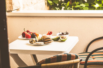 European healthy vegetarian food on a white table on the balcony.