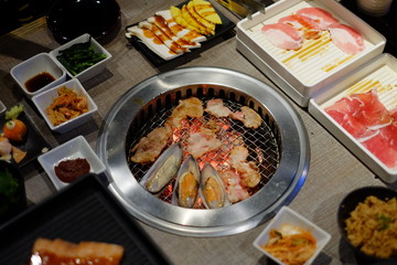 Top view cooking barbecue and grilled over charcoal on stove in Japan. Raw beef slice for barbecue or Japanese style yakiniku food.