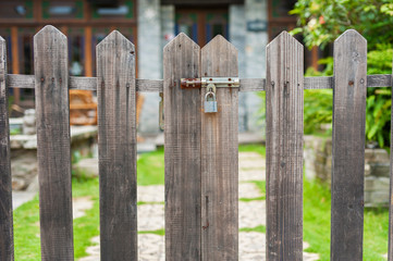 A closed gate of wooden fence of backyard garden