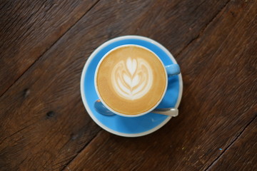 Top view A beautiful hot coffee with latte art on wooden table. Selective focus