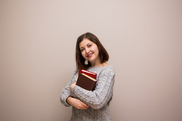 Fototapeta premium Portrait of young brunette woman with book in her hand