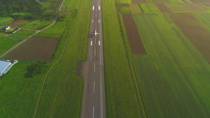 Aerial view of white plane launching from take off runaway in the air. 4K.