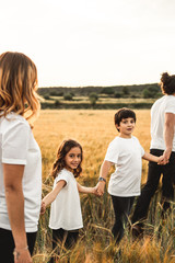 Family holding hands in the countryside happy