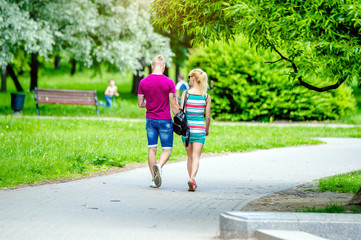 Obraz premium A guy and a girl walk along the path in the city Park 