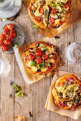 top view of delicious pizza with tomatoes on wooden table