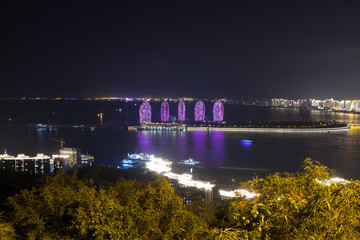 Phoenix - an artificial island off the coast of Hainan Island, China. Panorama of night city, sea and buildings of hotels Phoenix Island Resort Sanya
