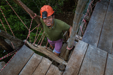 Obraz na płótnie Canvas Hombre subiendo escaleras para llegar a la cima del mirador en excursión. Hombre feliz con casco naranja para excursiones. Hombre trabajando con casco de seguridad.